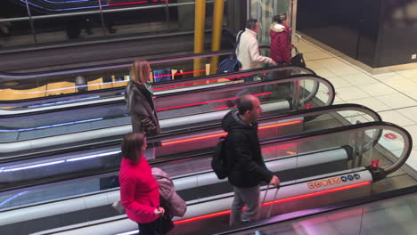 Two-row-escalator-stair-with-people,-parallel-escalator-staircase,-towing-carry-on-luggage,-busy-airport-terminal-scene,-passengers-rushing,-travel,-business-and-transportation-concept