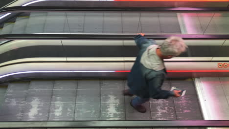 Hochwinkelaufnahme-Einer-Rolltreppe-Mit-Menschen-Darauf-Auf-Einem-Flughafen-In-Zeitlupe