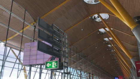 High-ceiling-covered-in-wood-and-supported-by-steal-beams-and-concrete-pillars,-T4-terminal-at-Madrid-Barajas-Airport,-modern-construction-and-architecture,-travel-and-transportation-concept