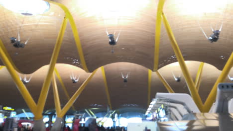 Long-panning-shot-of-airport-terminal,-passengers-rushing-in-all-directions,-check-in-counters-and-facility-areas-in-background,-modern-architecture-and-design,-travel-and-transportation-concept