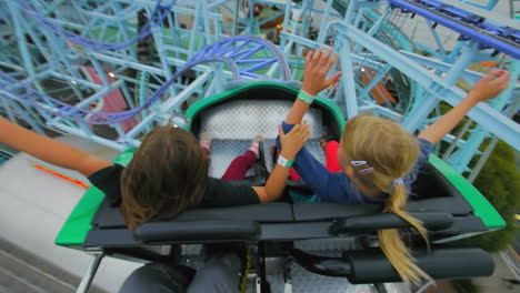 Children-and-enjoy-riding-a-rollercoaster-at-high-speeds-in-an-amusement-park-in-the-summertime