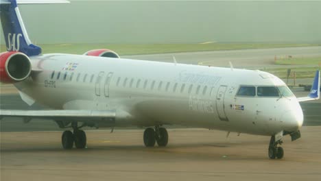 Close-up-of-an-airplane-leaving-the-runway-and-moving-towards-the-gates-on-a-foggy-day-at-Stockholm-Arlanda