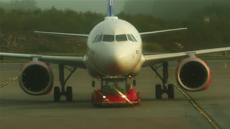 Ein-Flugzeug-Wird-Von-Einem-Schlepper-Gezogen-Und-Fliegt-Auf-Die-Tore-Zu