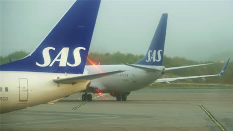 Un-Avión-Se-Aleja-Hacia-La-Izquierda-Mientras-Otro-Avión-Se-Mueve-Hacia-La-Derecha-Frente-Al-Primer-Avión-Con-La-Ayuda-De-Un-Remolcador