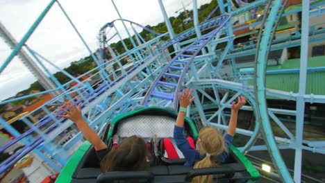 Children-and-enjoy-riding-a-rollercoaster-at-high-speeds-in-an-amusement-park-in-the-summertime