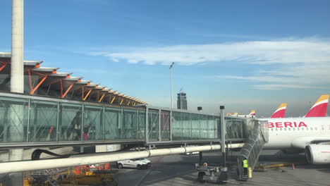 Passagiere,-Die-über-Eine-Luftbrücke-Am-Internationalen-Flughafen-Madrid-Barajas-In-Ein-Modernes-Düsenflugzeug-Einsteigen,-Servicemitarbeiter-Bereiten-Das-Flugzeug-Für-Den-Start-Vor,-Flugreisen,-Architektur-Und-Technisches-Konzept