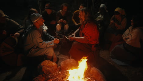 Vikingos-Socializando-E-Interactuando-Entre-Sí-Alrededor-De-Un-Fuego-En-Un-Pequeño-Y-Encantador-Pueblo-En-Una-Recreación-De-Un-Pueblo-De-La-época-Vikinga-En-Suecia