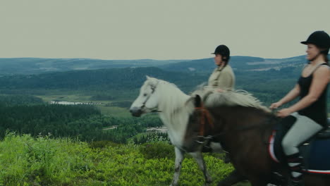 A-couple-of-women-riding-horses-on-a-high-mountain-pass-in-front-of-the-camera-in-Scandinavia,-the-North-of-Europe