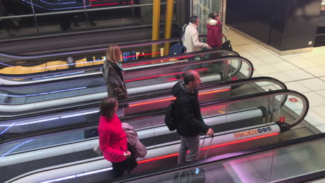 High-angle-shot-of-people-taking-escalators-in-an-airport-in-slow-motion