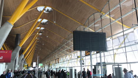 Slow-motion-shot-of-the-t4-in-Madrid-airport-with-people-walking-a-pan-to-the-ceiling