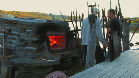 Video-of-people-talking-while-one-of-them-is-using-a-wood-burning-oven
