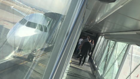 Dutch-angle-of-a-jetbridge-with-people-boarding-and-the-nose-of-a-plane