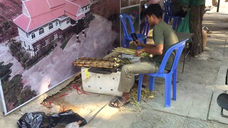 Mann-Schneidet-Bambus-Auf-Der-Straße-In-Phnom-Penh,-Kambodscha