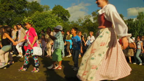 Personas-De-Todas-Las-Edades-Se-Reúnen,-Bailan-Y-Celebran-El-Festival-De-Mayo-De-Verano