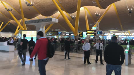 Langsamer-Schwenk-Nach-Rechts-Von-Menschen,-Die-Auf-Einem-Terminal-Des-Flughafens-Madrid-Laufen