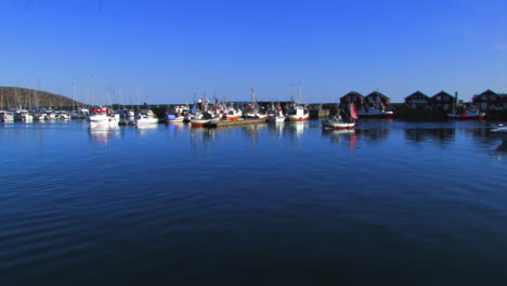 Harbor-scene-with-several-docked-boats-and-a-small-boat-going-by