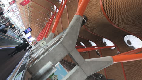 Dutch-angles-shot-of-an-autowalk-and-the-ceiling-of-Madrid-airport-with-a-big-circular-clock
