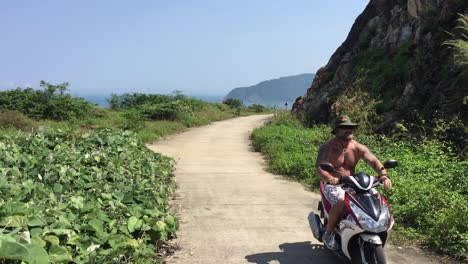Hombre-Conduciendo-Una-Bicicleta-Por-Una-Calle-Tranquila-En-Una-Montaña-En-Da-Nang,-Vietnam