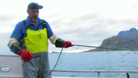 Fisherman-setting-his-net-in-the-onboard-pulley-as-he-prepares-to-pull-it-from-the-ocean