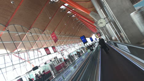 Dutch-angle-shot-of-a-man-walking-on-an-autowalk-in-an-airport-in-slow-motion