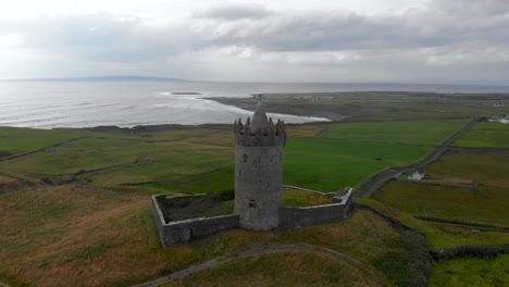 Doonagore-Castle,-Doolin-dolly-forward-view-of-Celtic-stronghold-Irish-fortification,-Seascape-coastal-landmark