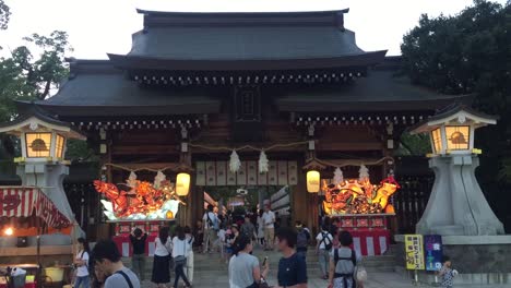 People-walking-under-a-Japanese-Building-in-Osaka,-Japan