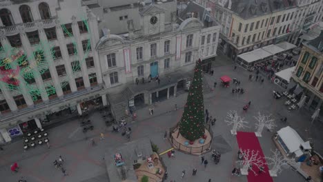 People-walking-by-Christmas-tree-and-decorations-in-Lille-city,-France