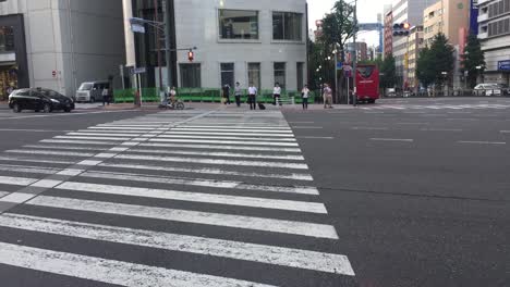 Cars-driving-through-an-intersection-in-Osaka,-Japan