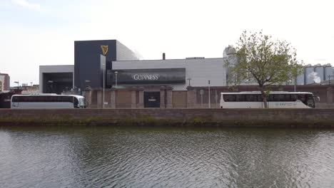 Exterior-view-of-Guinness-Factory-storehouse-next-to-river-Liffey,-panning-shot