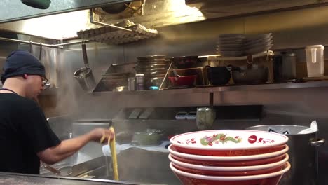 Hombre-Cocinando-Comida-Japonesa-En-Osaka,-Japón.