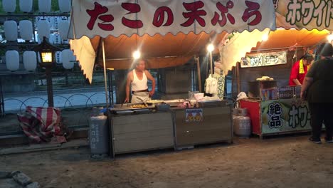 Street-vendor-cooking-on-the-street-in-Osaka,-Japan-at-night