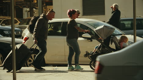 Father-dragging-suitcases-and-mother-pulling-the-stroller-with-two-children-malaga-airport