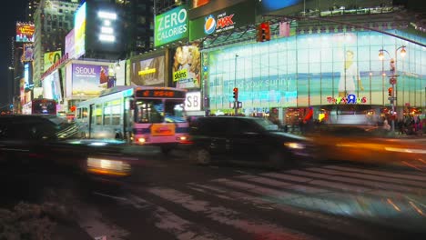 Die-Straßen-Der-Stadt-Sind-Voller-Gelber-Taxis-Und-Verkehr,-Während-Massen-Von-Touristen-Nachts-Auf-Einem-Bemalten-Zebrastreifen-Des-Berühmten-Times-Square-In-New-York-Die-Straße-überqueren