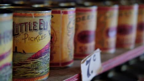 Vintage-museum-collection-of-old-fashioned-pickles-tin-cans-on-wooden-shelf