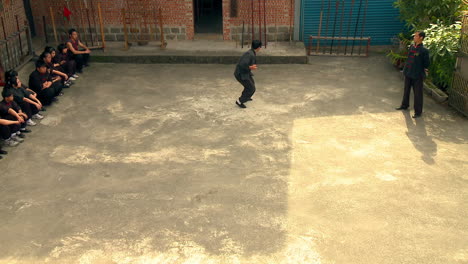 Rookie-practicing-dojo-hits-at-shrine-space-with-onlookers-watching