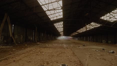 POV-View-Across-Large-Abandoned-Warehouse-With-Rubbish-On-The-Floor