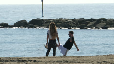 Young-couple-playing-football-with-a-ball-on-the-beach-SLOMO