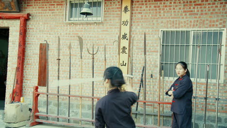 Asian-Martial-Arts-Girls-playing-with-Wooden-Sword-at-Sports-School