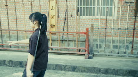Junges-Asiatisches-Mädchen-Trainiert-Mit-Orientalischem-Kampfkunstschwert