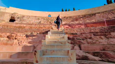 Female-Tourist-Walking-Up-Steps,-Cartagena-Amphitheater