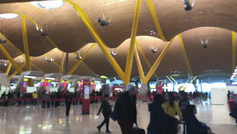 Schwenk-In-Einem-Terminal-Des-Flughafens-Madrid-Mit-Menschen,-Die-Mit-Gepäck-Gehen