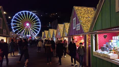 slow-motion-handheld-shot-of-many-visitors-in-the-alley-of-the-annual-Christmas-Market-in-Monte-Carlo,-Monaco