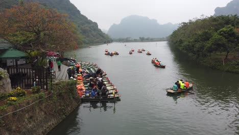 Row-boats-Ninh-Binh-Vietnam,-tourists-getting-in-row-boats-at-entrance