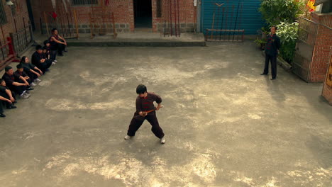 Deshi-Practicando-Lucha-Con-Palos-De-Espada-En-El-área-De-Entrenamiento-De-Guan