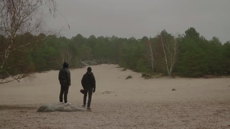Zwei-Erwachsene-Stehen-Am-Sandstrand-Der-Cul-Du-Chien-Und-Blicken-Auf-Die-Wälder-Von-Fontainebleau,-Frankreich