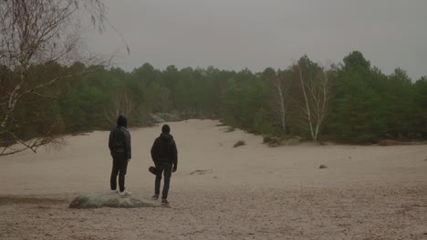 Dos-Adultos-De-Pie-En-Las-Arenas-Del-Cul-Du-Chien-Mirando-A-Los-Bosques-De-Fontainebleau,-Francia