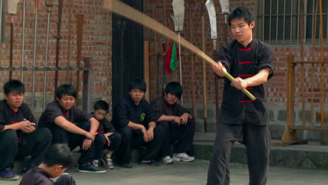 Dos-Discípulos-De-Artes-Marciales-En-Una-Lucha-Simulada-Escenificada-Con-Palos.