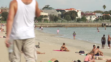 Sonnenbaden-Am-Strand-An-Einem-Warmen,-Sonnigen-Tag-Mit-Spaziergängern-Und-Möwen