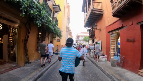 A-man-is-singing-and-playing-the-guitar-as-he-walks-down-a-street-of-the-old-town-of-Cartagena-de-Indias,-Colombia