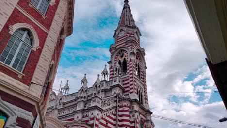 Eine-Wunderschöne-Kathedrale-Mit-Roten-Und-Weißen-Streifen-Und-Einer-Uhr-Auf-Der-Kuppel-In-Der-Altstadt-Von-Bogotá,-Kolumbien